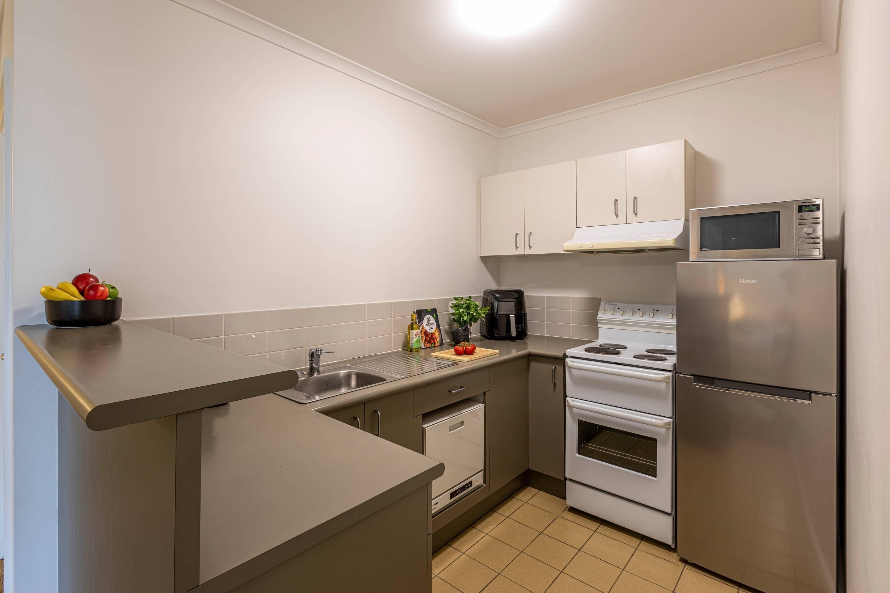 A modern kitchen with stainless steel appliances, a microwave, and a coffee maker.