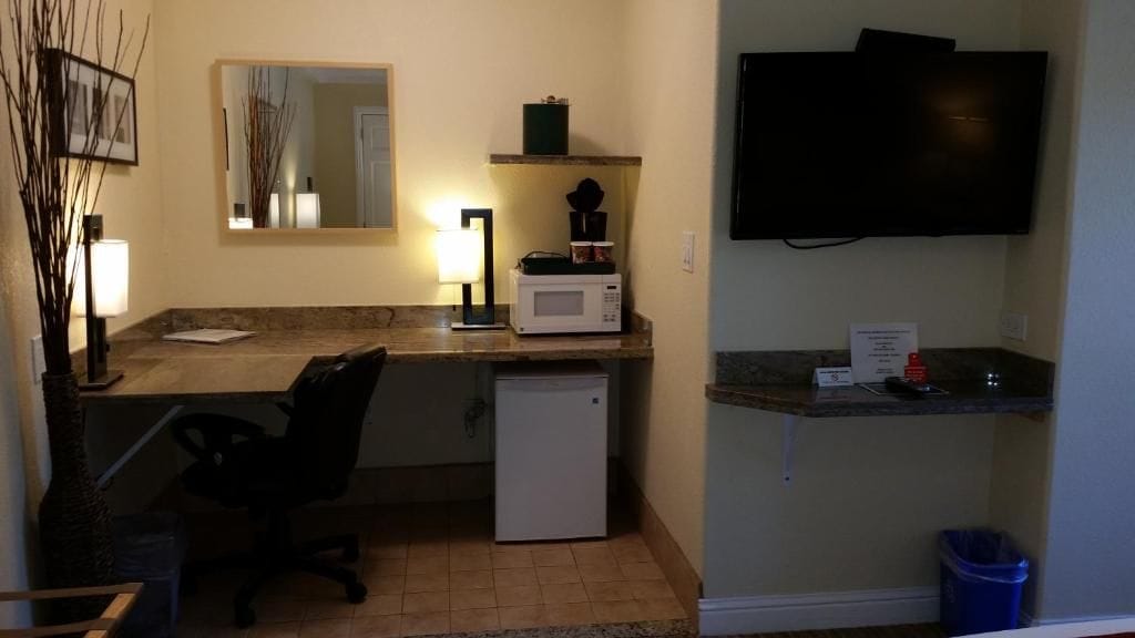 A compact kitchenette with a microwave, coffee maker, and a small refrigerator.