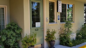 A building with a sign labeled "OFFICE" on the front door, a "NO SMOKING" sign, and a welcome sign. - Marin Lodge (San Rafael)