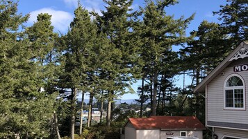 A guest spa building with a red roof, surrounded by tall evergreen trees.