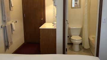 Un baño con inodoro, lavabo y cortina de ducha.