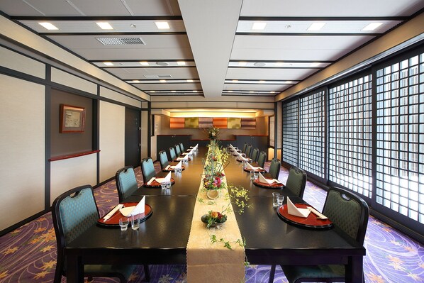 Une salle de conférence avec une longue table, des chaises et un élément décoratif au centre.