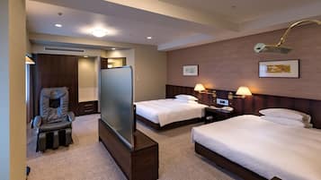 Ein Hotelzimmer mit zwei Betten, einem Massagesessel, einem Fernseher und einem Schreibtisch mit einer Lampe.