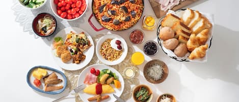 A variety of dishes including pasta, bread, and salads, arranged on a table.