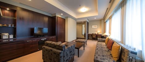 A modern living room with dark wood furniture, a flat-screen TV, and a large window with curtains.