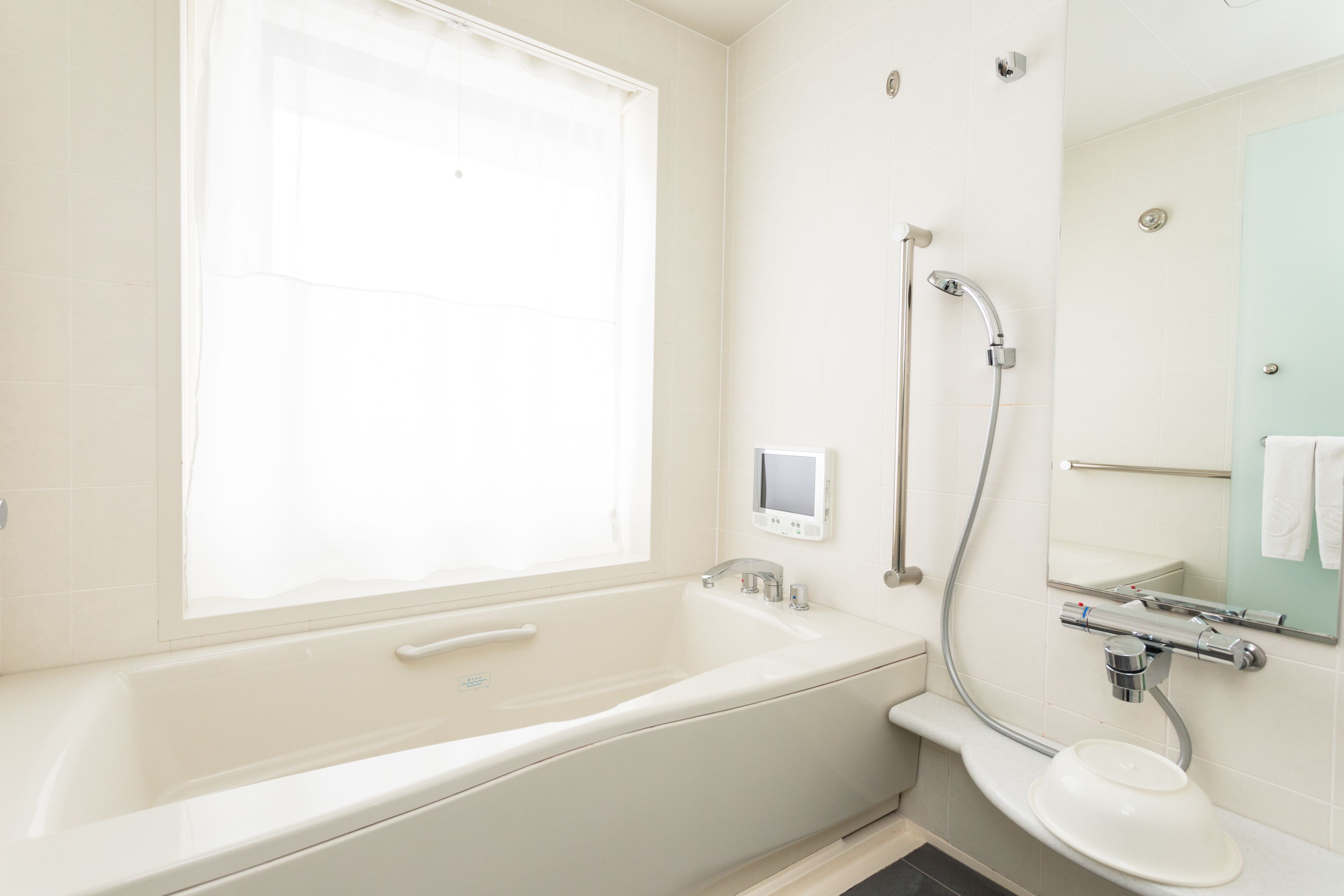 A modern bathroom with a bathtub, a toilet, and a shower.