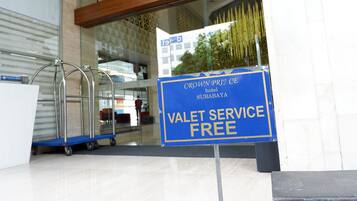 Een hotelingang met een bord waarop staat dat de parkeerservice gratis is.