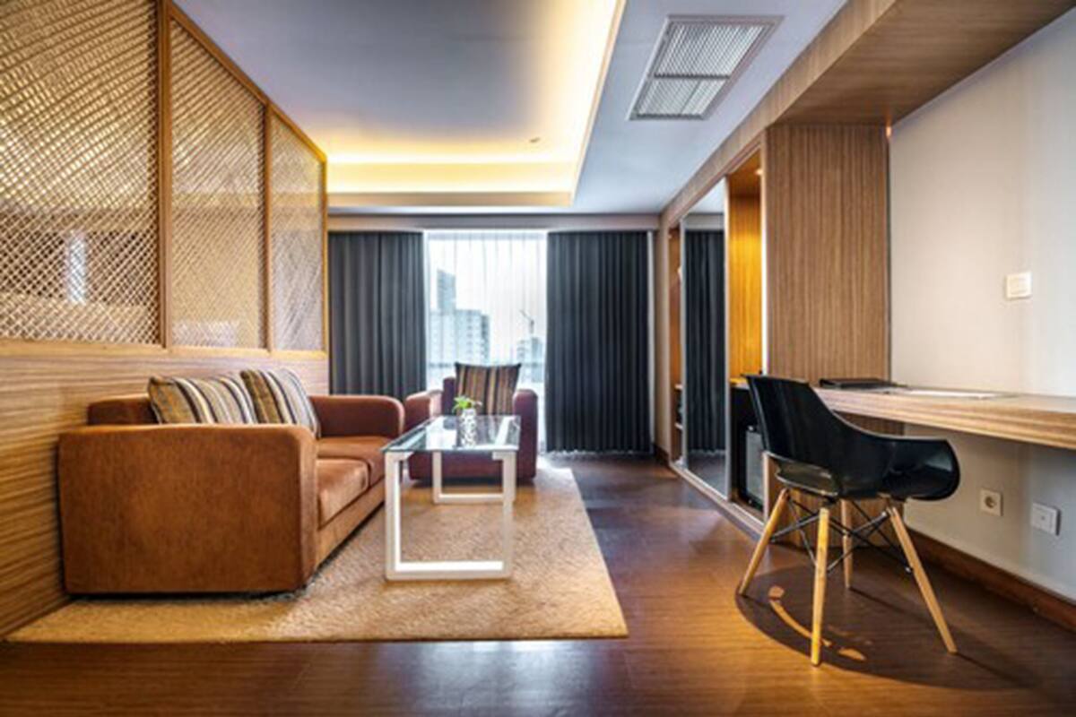 A modern living room with a sofa, coffee table, and a dining area with a chair and table.