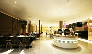 Un restaurant moderne doté d’un bar central circulaire, de nombreuses tables et de chaises.