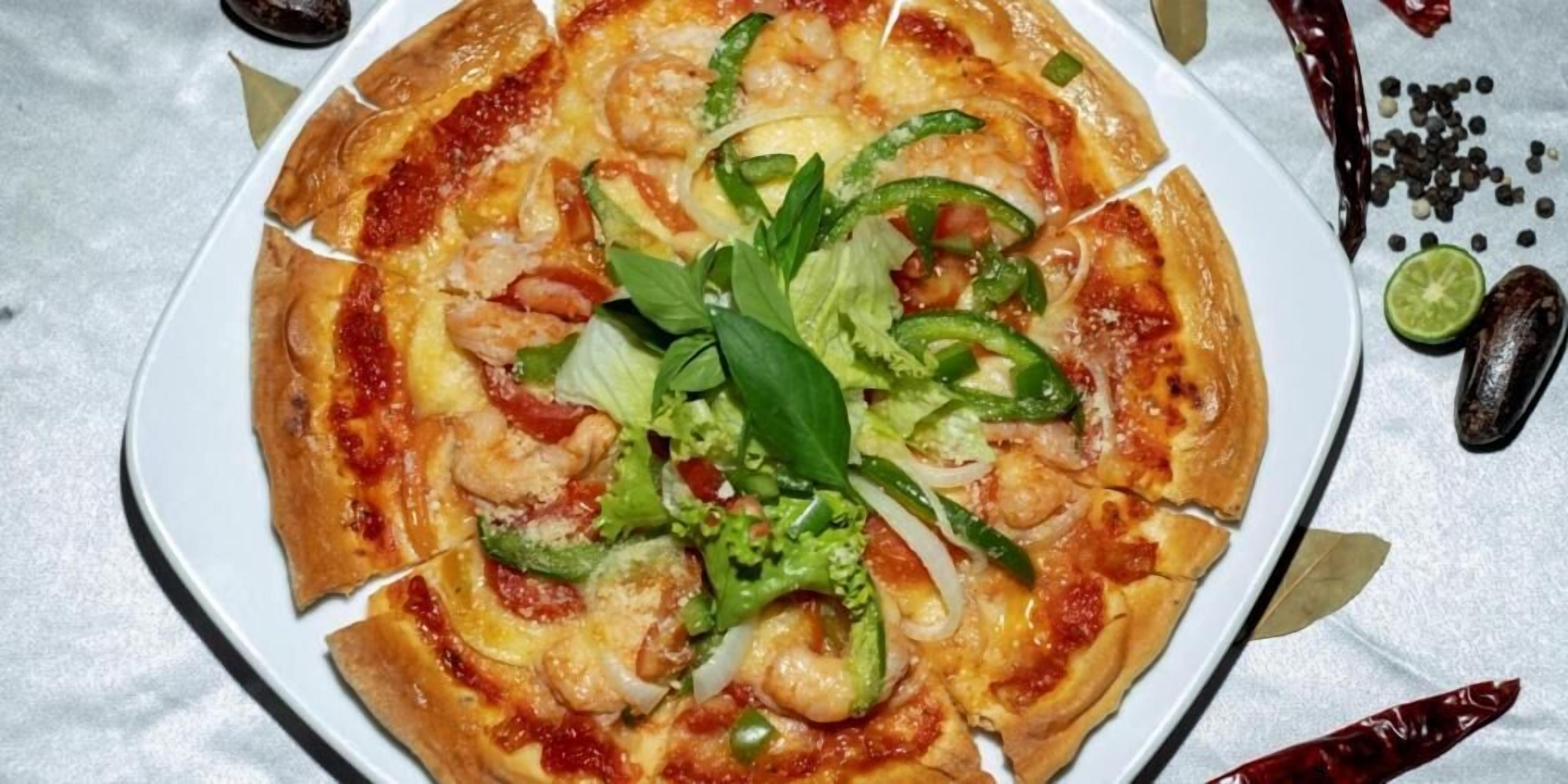 Een pizza met toppings en garnering op een bord.