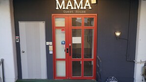A building with a red door labeled "MAMA Guest House" and a sign indicating a 3-star rating.