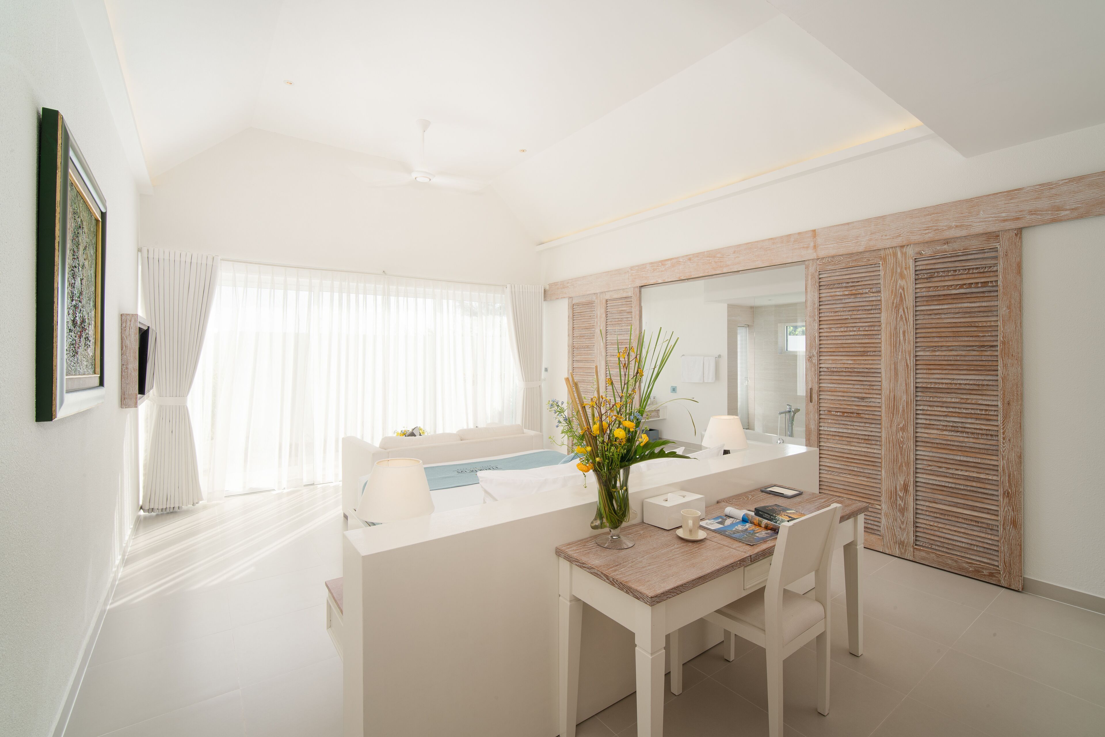Un baño moderno con un espejo grande, una bañera y un tocador con lavabo.