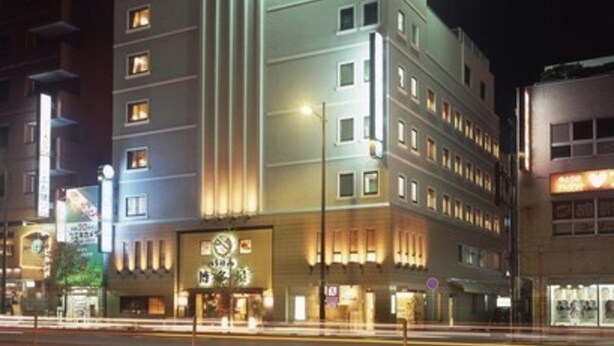 Een hotel met meerdere verdiepingen, verlichte signage en een opvallende ingang.
