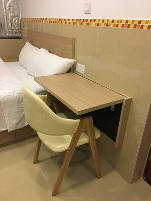 A small, neatly arranged bedroom with a bed, a wooden desk, and a chair. - Hong Kong Hostel (Hong Kong)