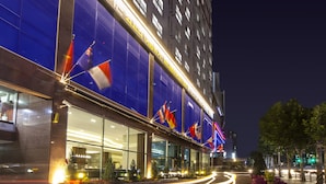 A hotel with large glass windows, flags, and a modern facade. - Hotel Bernoui Seoul (Seoul)