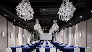 A conference room with rows of tables and chairs, large chandeliers, and brick walls. - Hotel Bernoui Seoul (Seoul)
