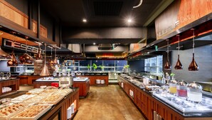 A buffet setup with various food items and beverages, wooden cabinets, and hanging pendant lights. - Hotel Bernoui Seoul (Seoul)
