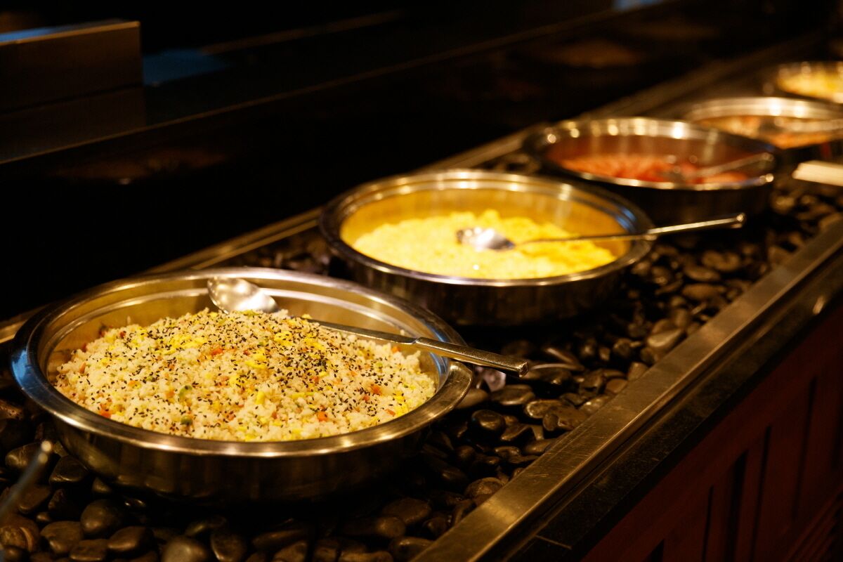 A buffet with various dishes in metal serving containers.