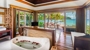 Ein luxuriöses Badezimmer mit einer großzügigen Badewanne, einem Schminktisch und einem Fernseher.