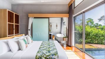A modern bedroom with a large bed, a wooden wardrobe, a bathroom with a bathtub, and a view of a swimming pool and greenery.