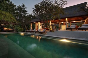 Un espace aménagé au bord de la piscine, avec des chaises longues et un coin salon abrité.