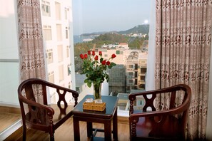 Habitación senior, vista parcial al océano | Área de sala de estar | Televisión de pantalla plana