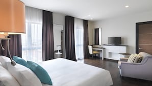 A hotel room with a large bed, a desk with a chair, a television, and a sofa. - Wyndham Garden i-City Shah Alam (Shah Alam)