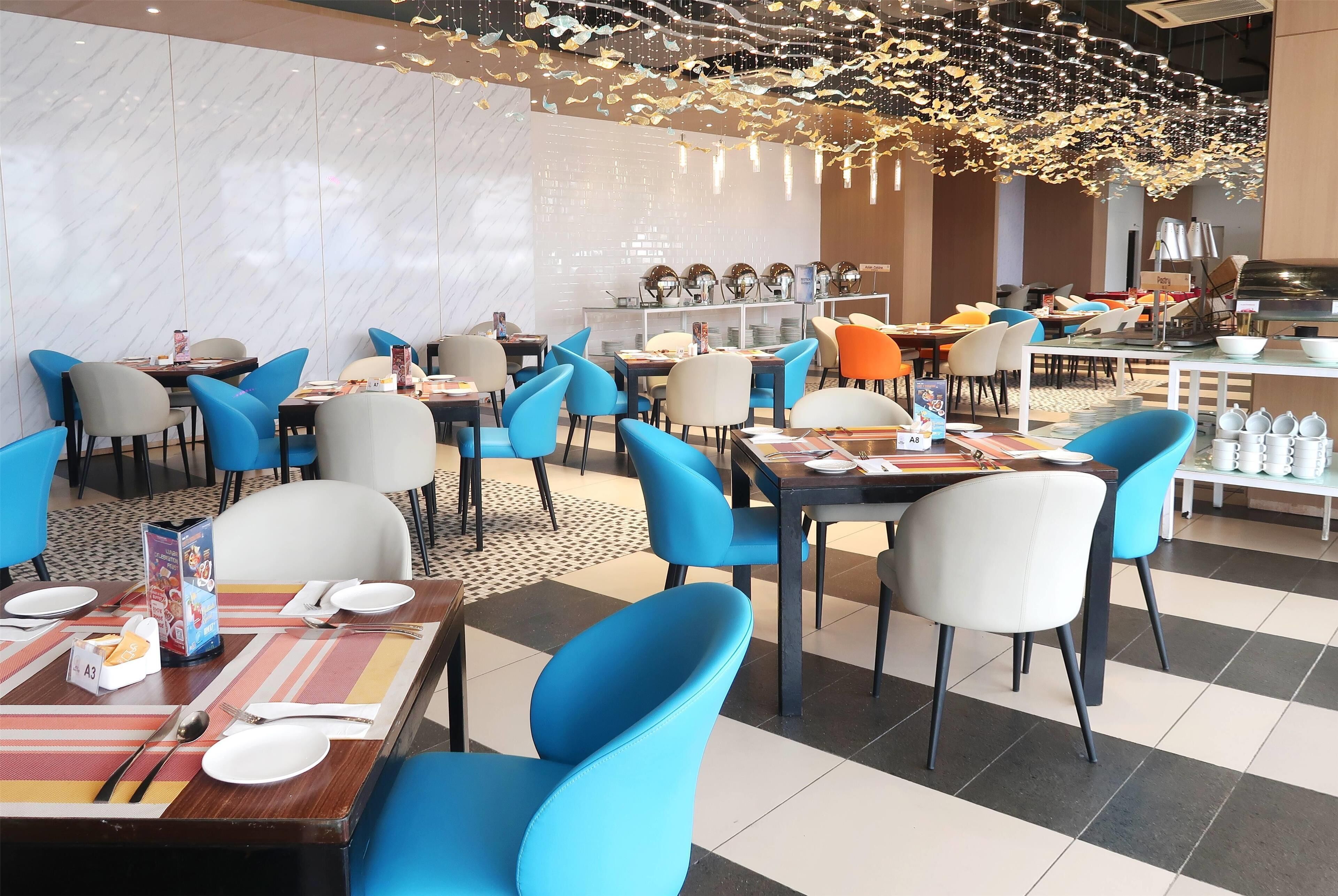 A restaurant with multiple tables and chairs, some with menus and cutlery.