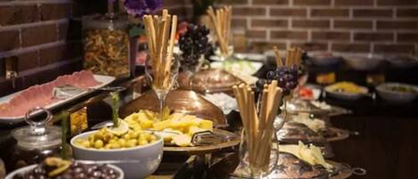 A buffet table with various food items and utensils.
