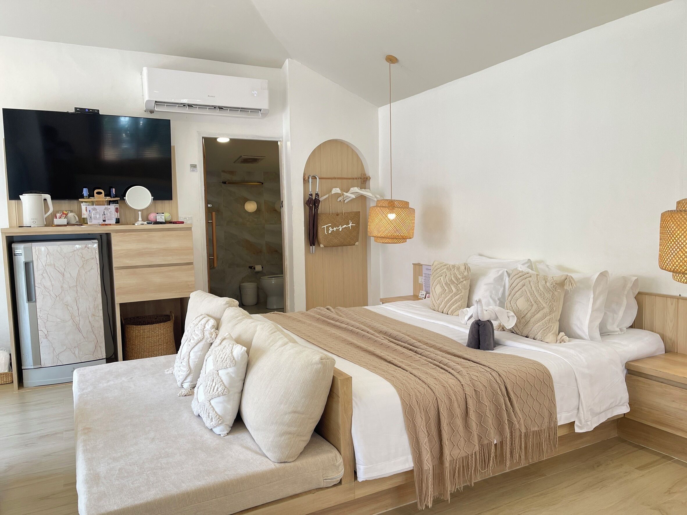 A modern hotel room with a bed, bedside table, and a TV.