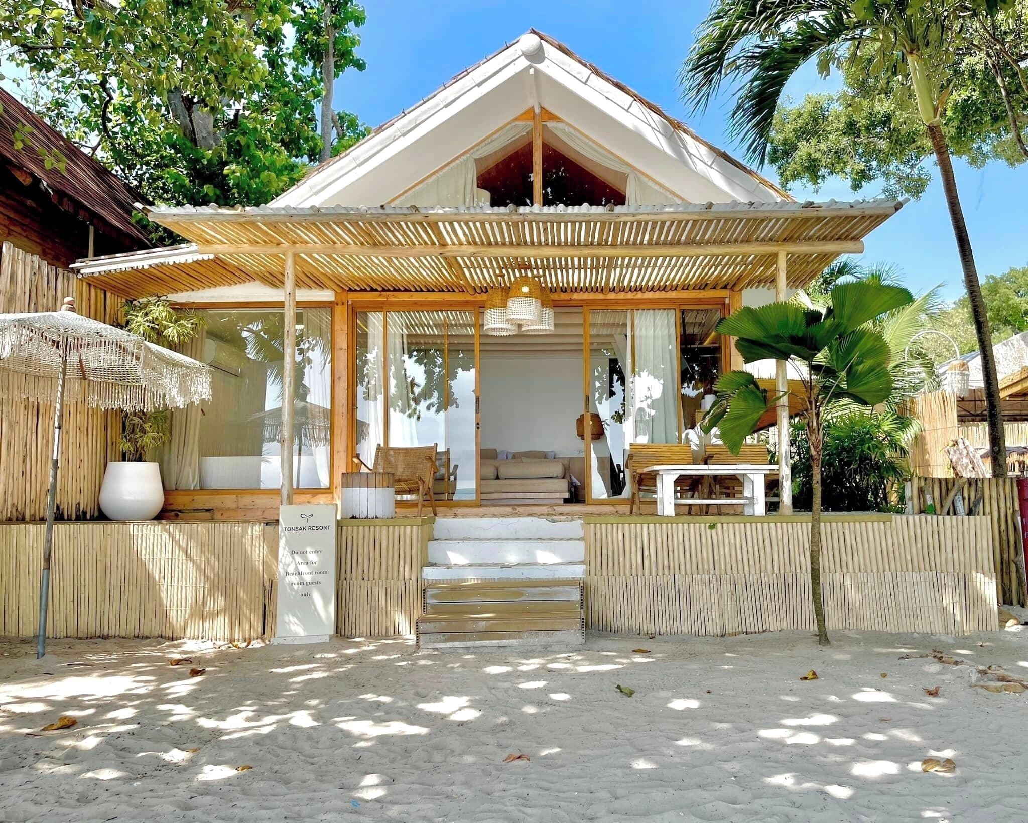 A resort with a covered entrance, outdoor seating, and a sign indicating guest-only areas.