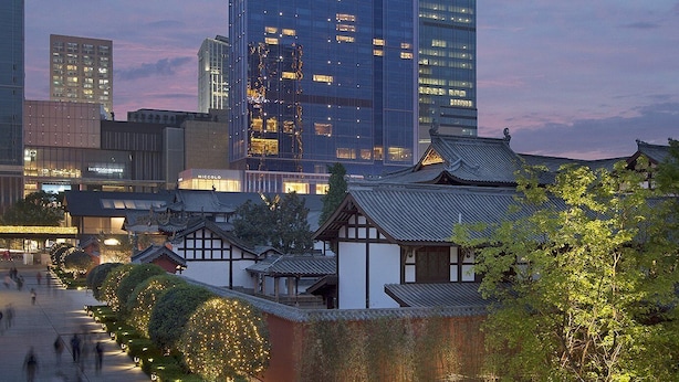 A modern skyscraper with glass facade, adjacent traditional architecture, and a pedestrian walkway. - Niccolo Chengdu (Chengdu)