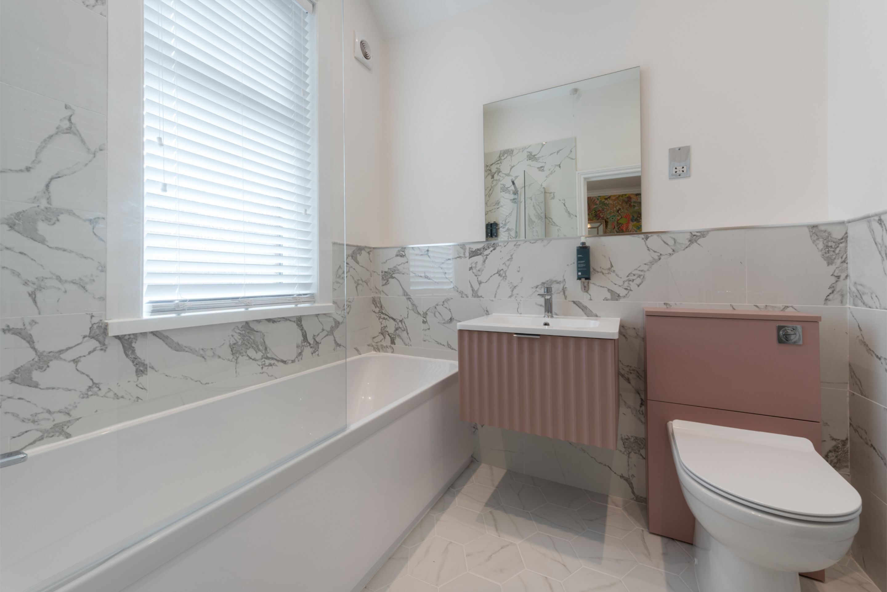 A bathroom with a bathtub, sink, and toilet.