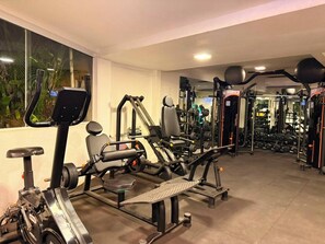 A gym with various exercise equipment, including treadmills, weight machines, and free weights. - Pousada Casacolina (Búzios)