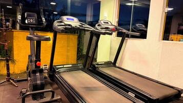 Un gimnasio con cintas de correr y una máquina elíptica.