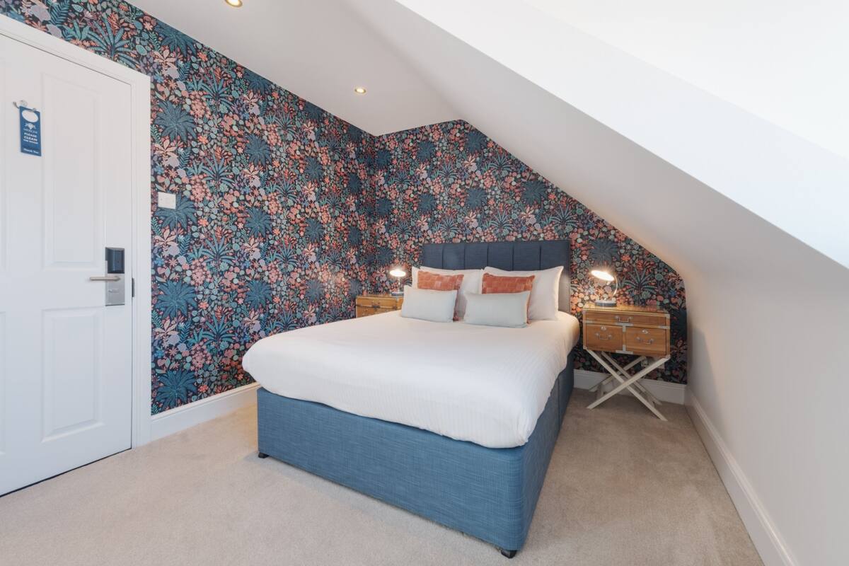 A bedroom with a bed, a nightstand, and a dresser.