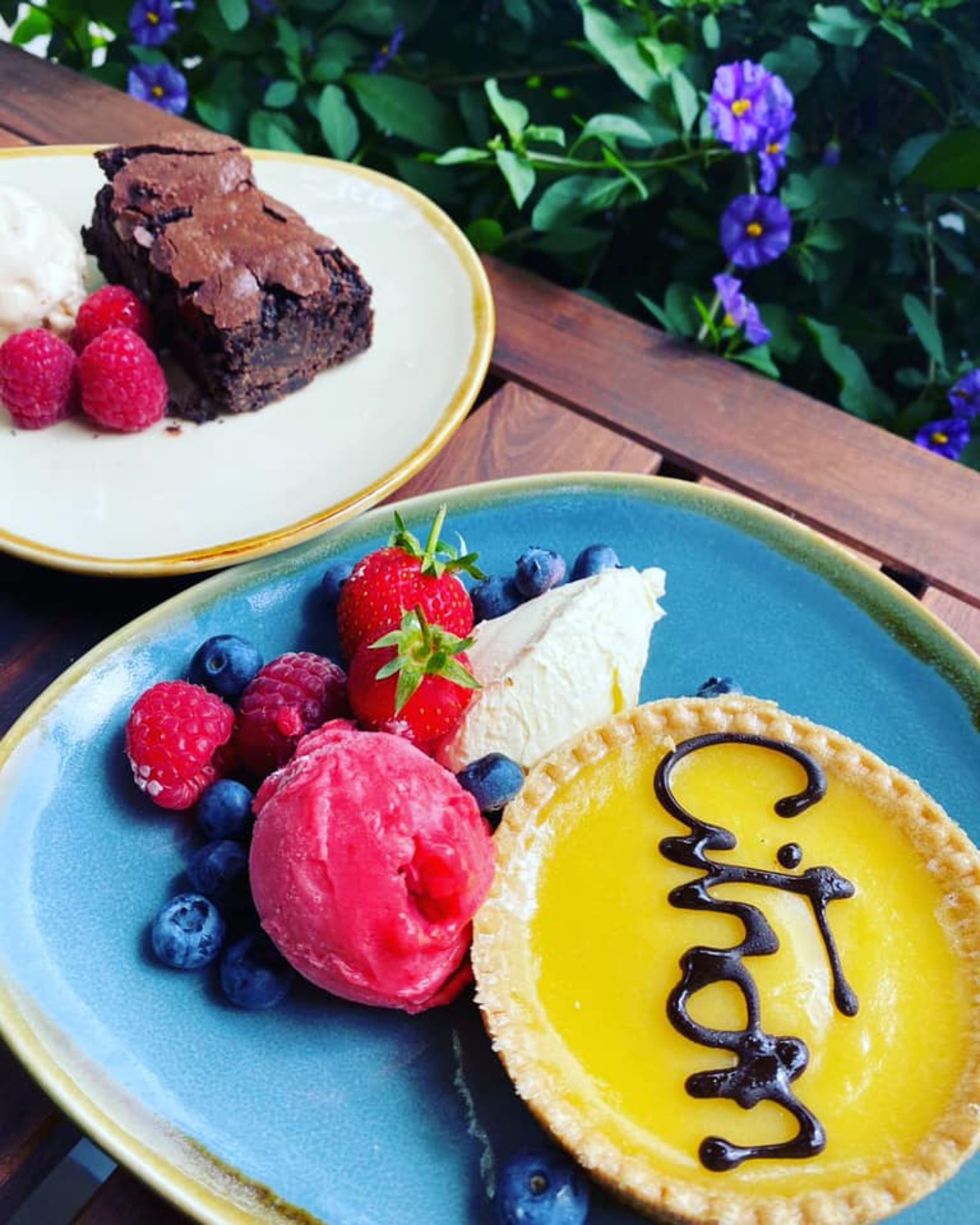 A dessert plate with a tart, ice cream, and berries.