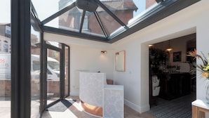A modern interior with a glass ceiling, a reception desk, and a kitchen area. - Florence Gardens Hotel & Restaurant (Portsmouth)