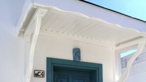 A blue door with a decorative pattern, a small sign with the letter "C" above it, and a white porch with a simple design. - Via Farilya Hotel (Bodrum)