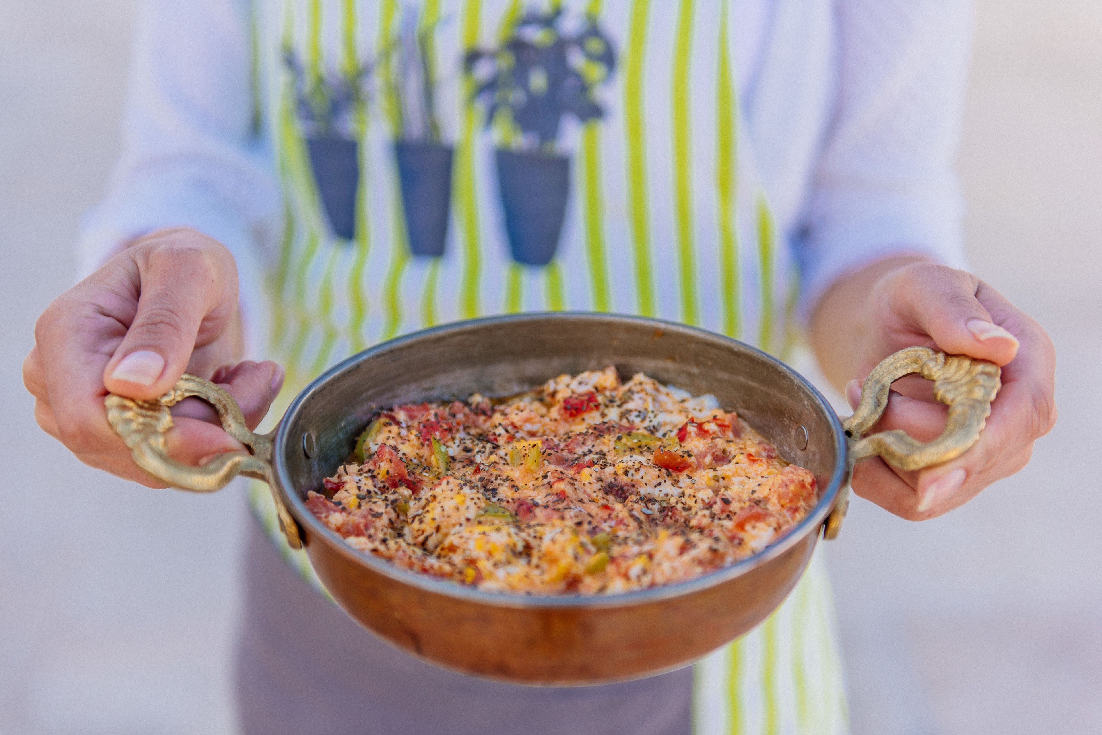 A person holding a pot with a dish inside.
