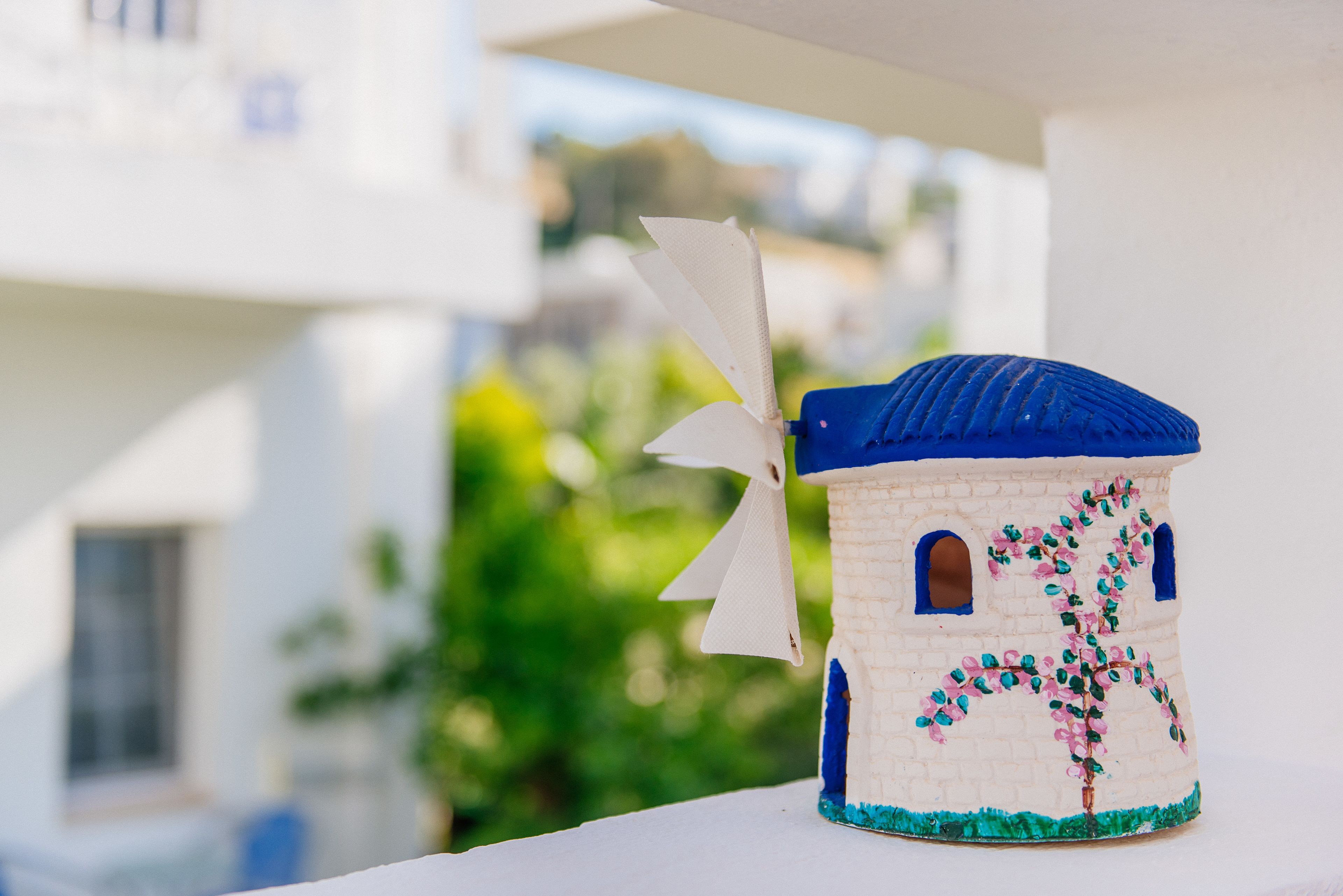 Modelo de un edificio blanco y azul con un árbol y una bandera.