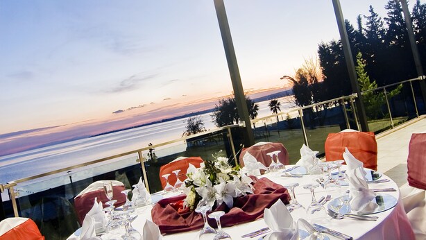 Une table ronde dressée pour un repas, avec vue sur la mer.
