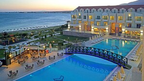 Un hôtel doté d’une grande piscine, d’un espace extérieur aménagé et offrant une vue sur la mer.