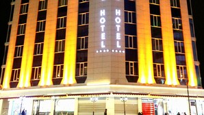 Un hotel alto con un llamativo letrero vertical que dice "Prestige Hotel".