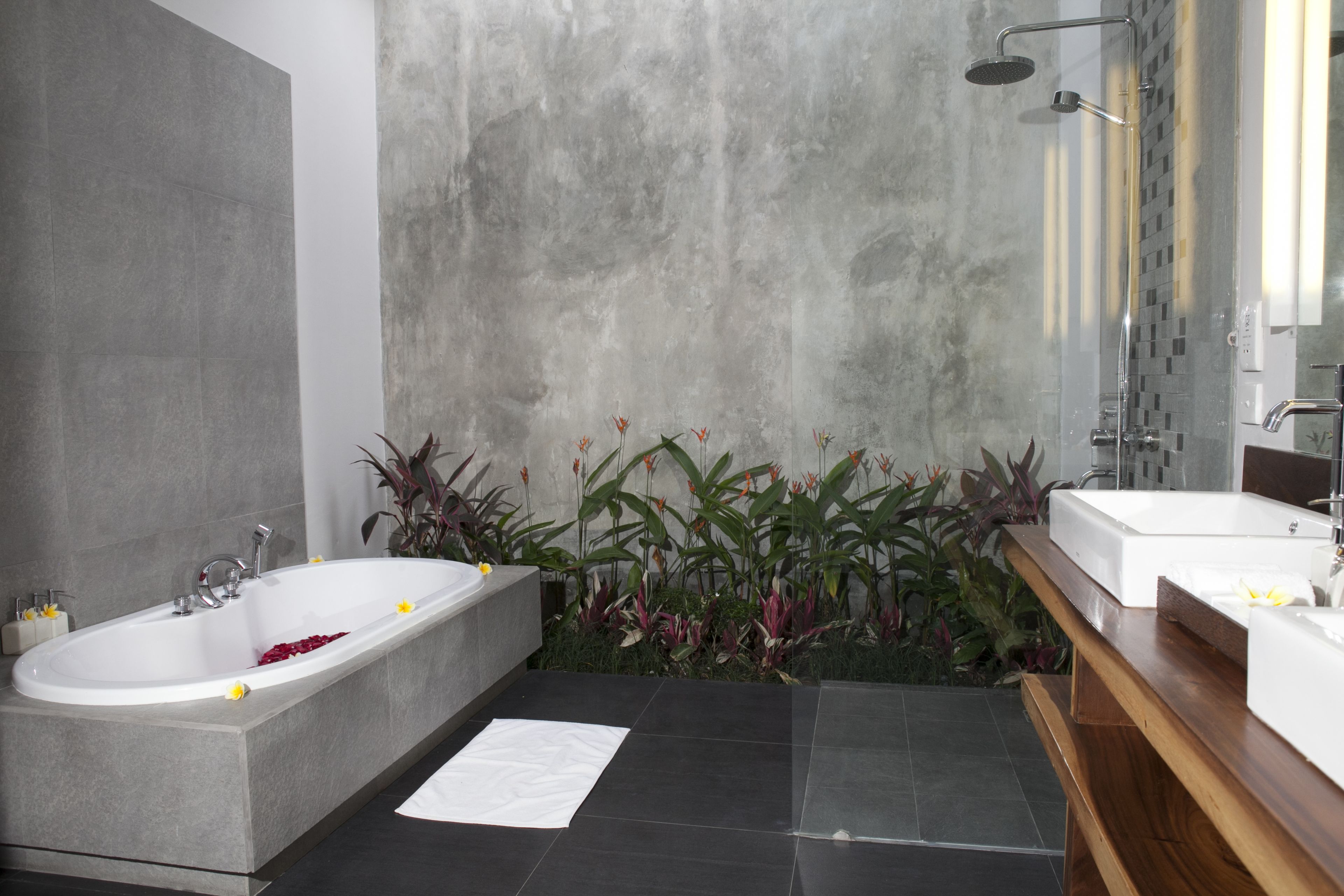 Ein modernes Badezimmer mit einer freistehenden Badewanne, einer Dusche und einem Holzausleger.
