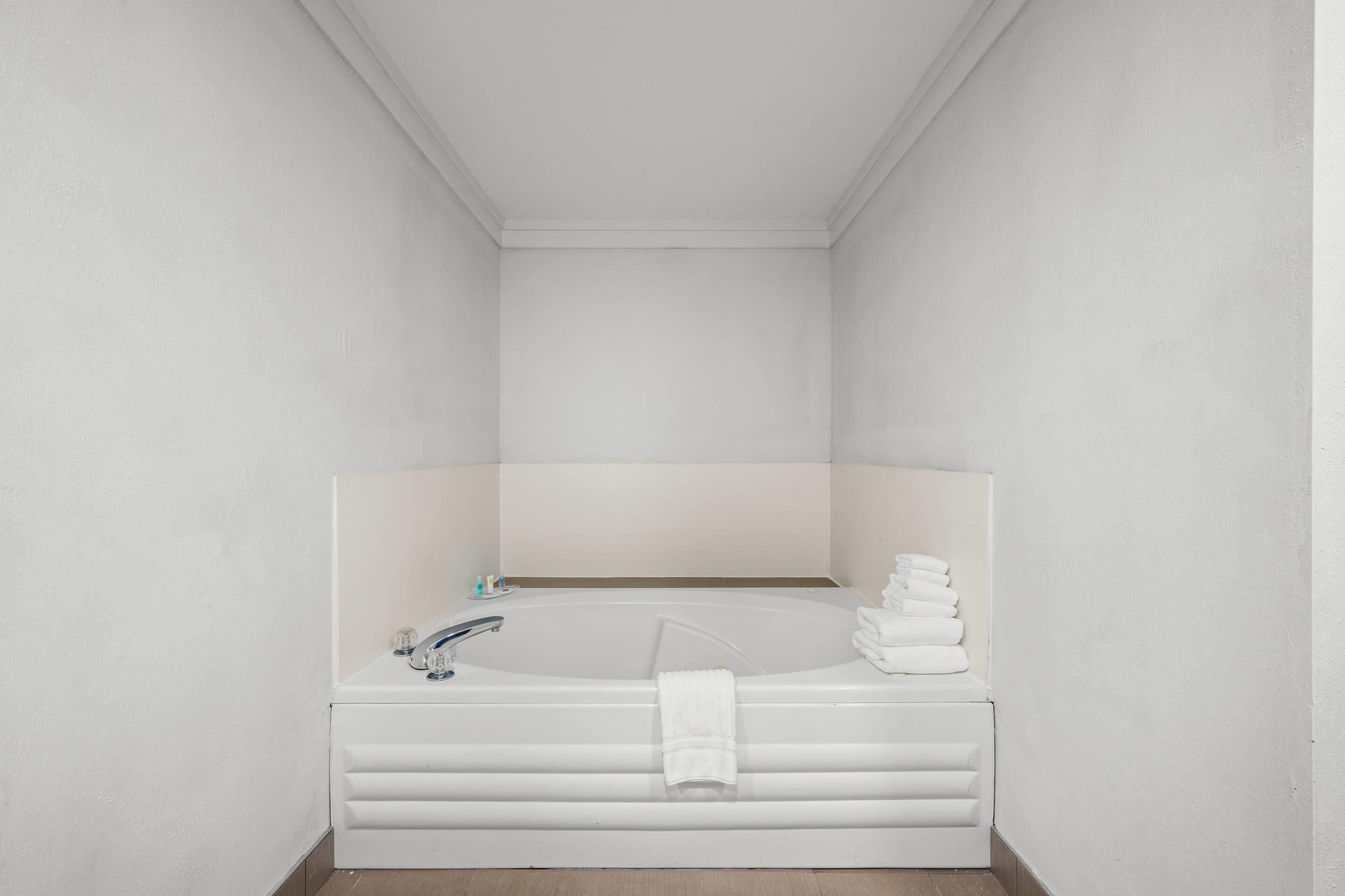 A modern bathroom with a freestanding bathtub, a vanity with a mirror, and a towel rack.
