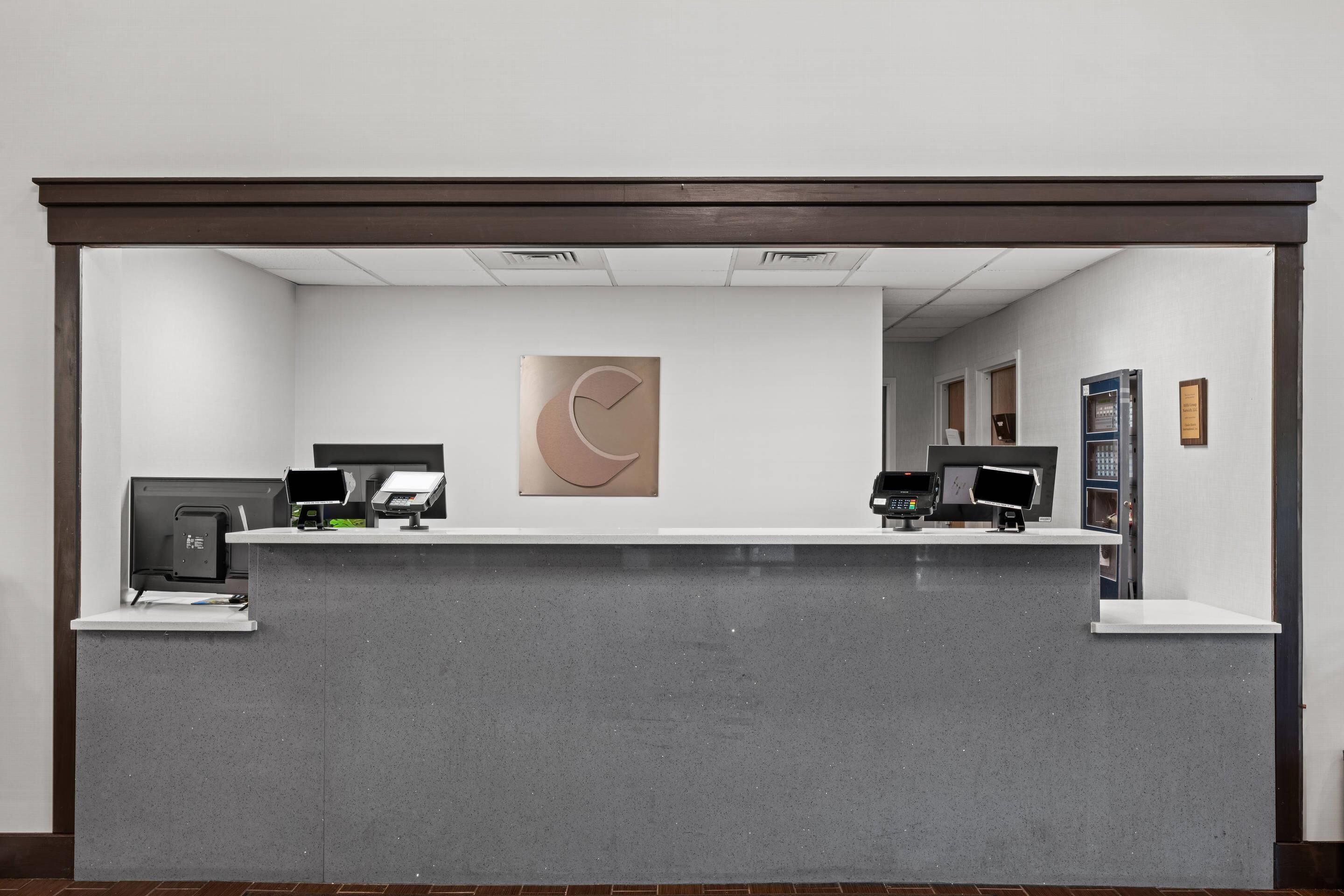 A reception desk with a modern design, featuring a large abstract artwork above it.