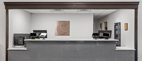 A reception desk with a modern design, featuring a large abstract artwork above it.
