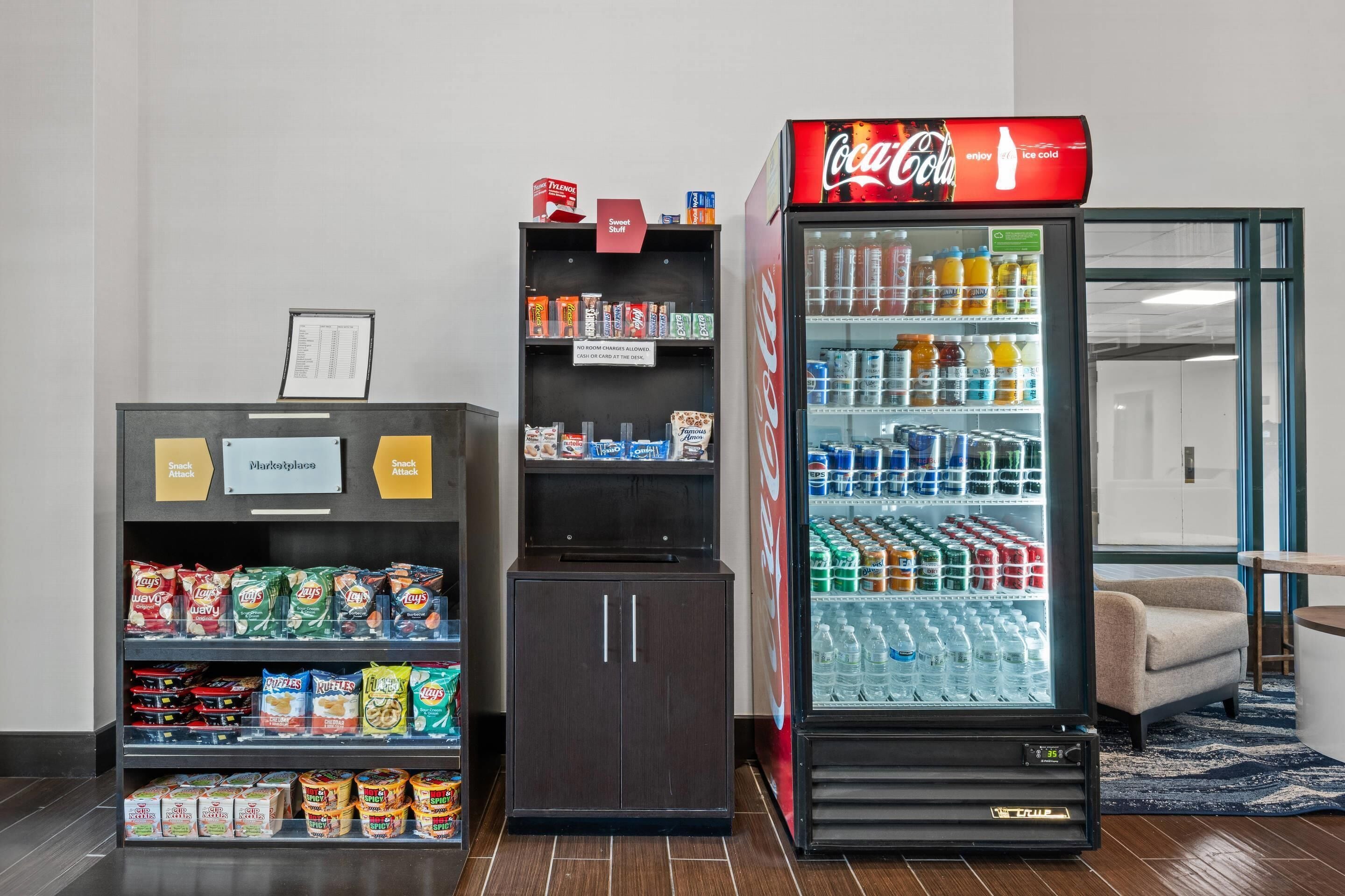 Máquina expendedora con aperitivos y un refrigerador de Coca-Cola.