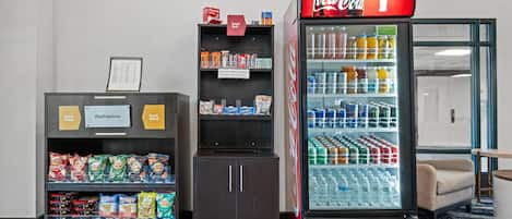 En automat med snacks og et køleskab med Coca-Cola.